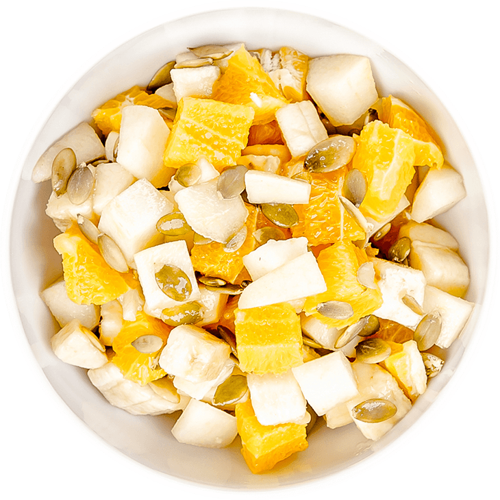 Obstsalat mit Banane, Orange, Birne und Kürbiskernen