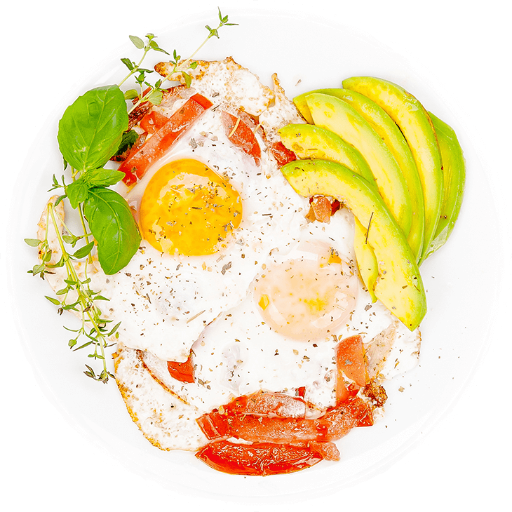 Fried eggs on ham and tomato served with avocado